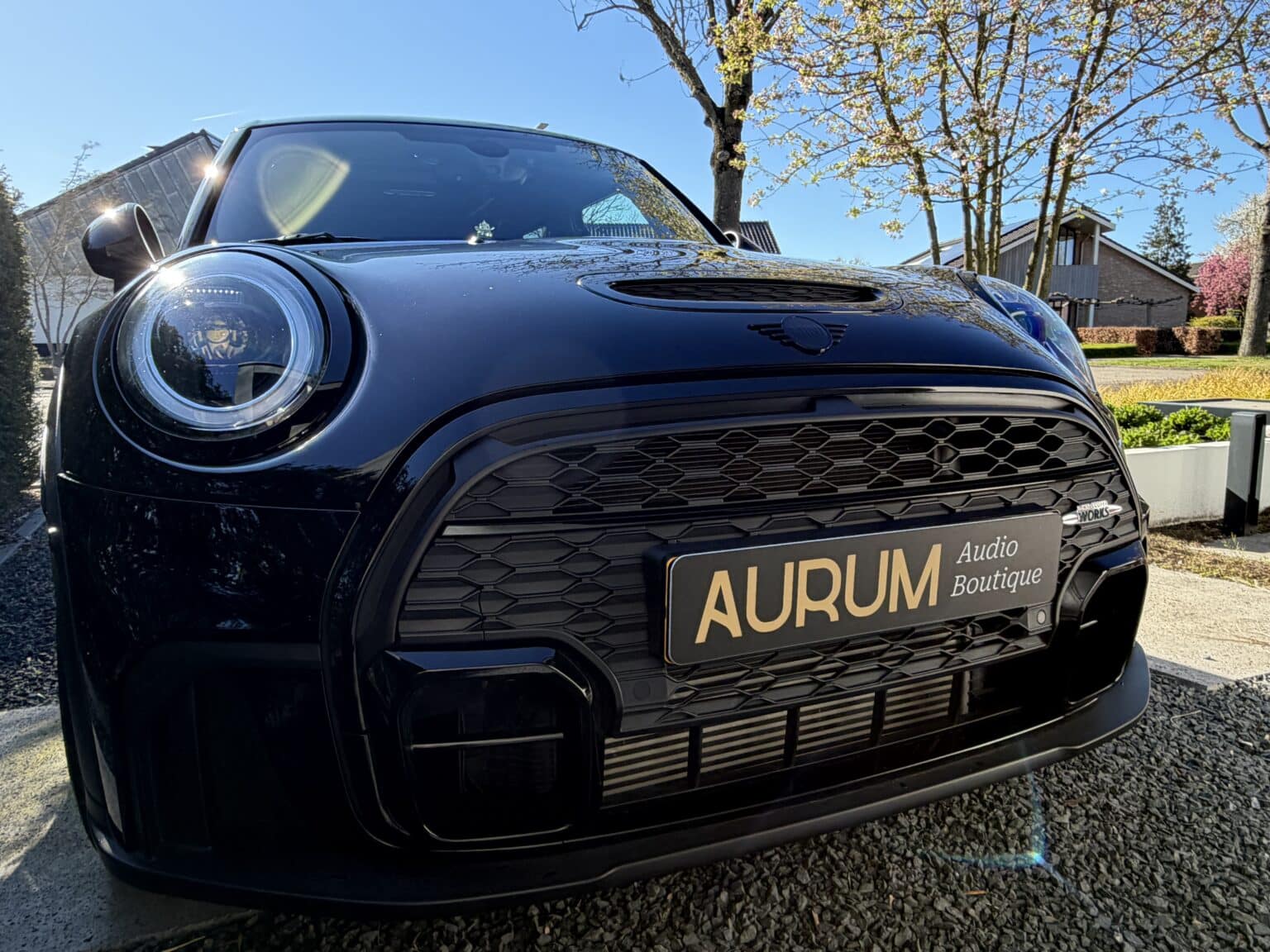 Voorkant van een zwarte MINI Cooper JCW bij Aurum Boutique, specialist in high-end car audio en premium audiosystemen.